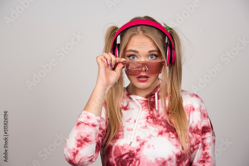 Blonde woman in pink glasses posing at camera