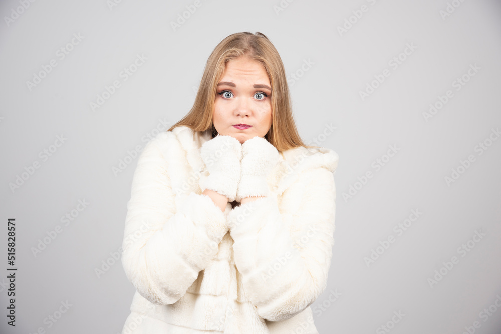 Beautiful woman in winter outfit feeling shocked