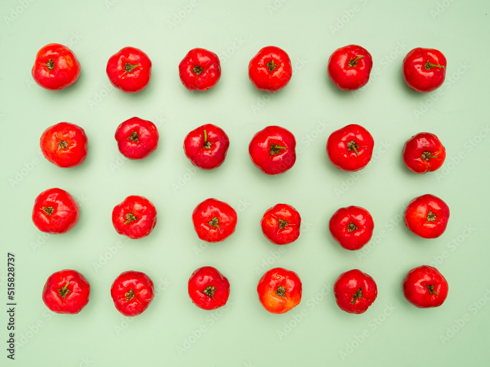Ripe red acerola cherries isolated on a light green background Ripe red acerola cherries isolated on a light green background