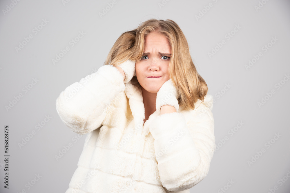 Blonde woman in winter outfit holding her hair Blonde woman in winter outfit holding her hair