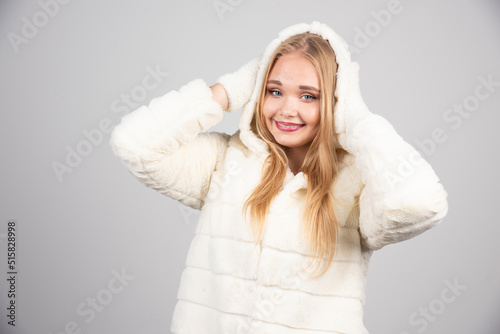 Young woman in fur coat holding her head