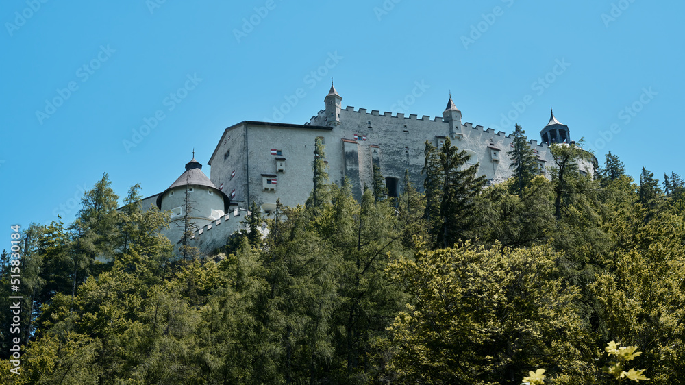Medieval defensive castle Hohenwerfen on a hill above a forest in Austria