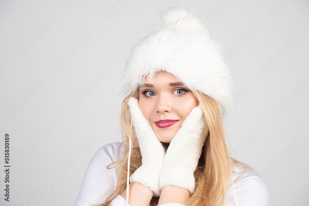 Blonde woman in winter outfit holding her cheeks Blonde woman in winter outfit holding her cheeks