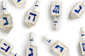 Dreidel also dreidle or dreidl with blue lettering on white background. Four-sided spinning top, played during the Jewish holiday of Hanukkah Jewish variant on the teetotum. Wooden gambling toy