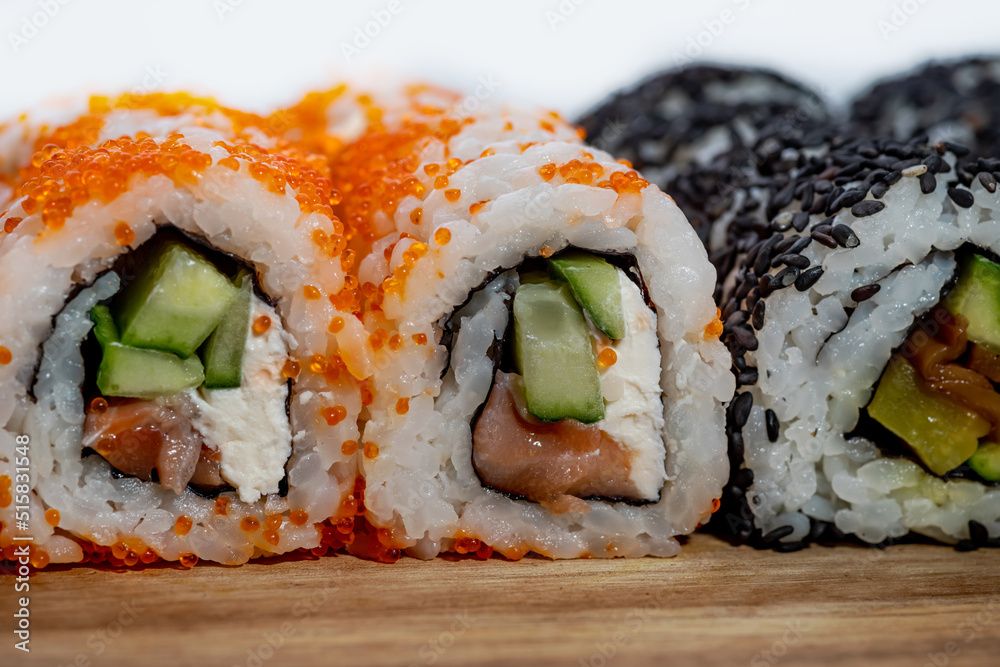 Close view of Sushi rolls in a Japanese restaurant. Appetizer Makizushi delicious traditional food of rice, seafood, avocado, fish salmon Close view of Sushi rolls in a Japanese restaurant. Appetizer Makizushi delicious traditional food of rice, seafood, avocado, fish salmon