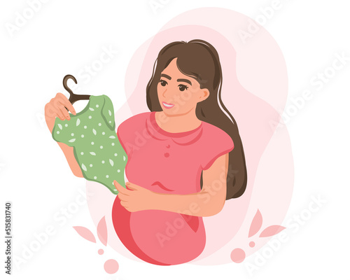 A pregnant mother holds baby clothes in her hands, a happy expectant mother is expecting a baby. Preparing for childbirth, a girl with a big belly in late pregnancy, the concept of motherhood