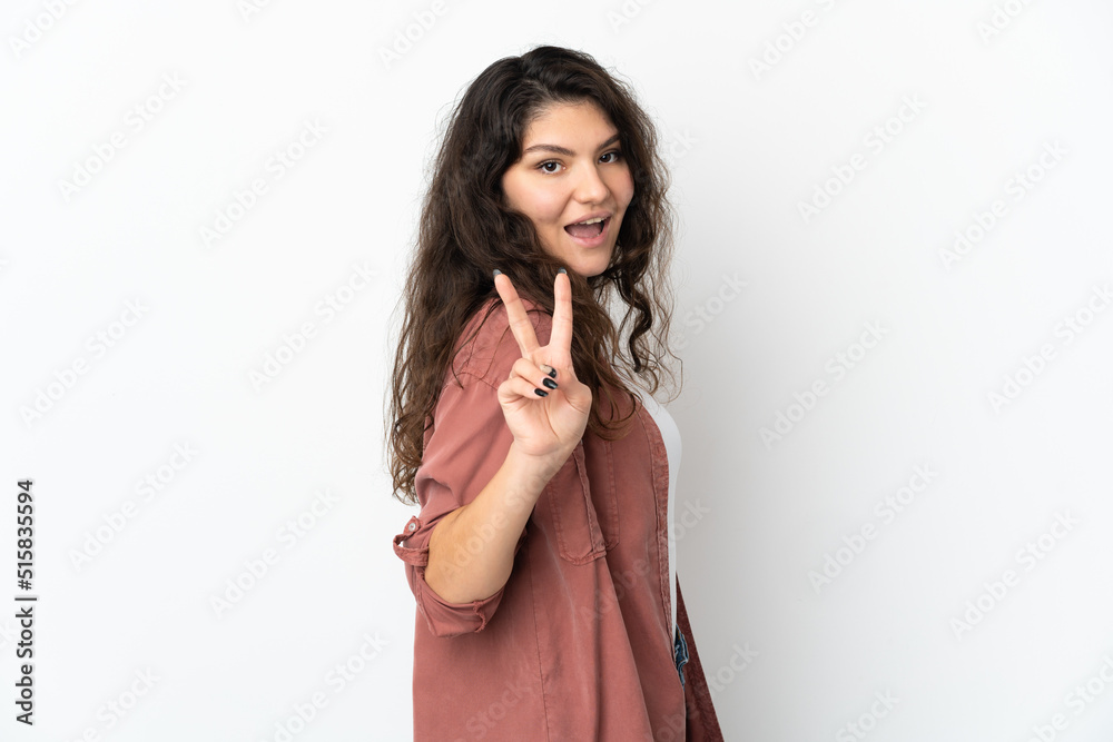 Teenager Russian girl isolated on white background smiling and showing victory sign