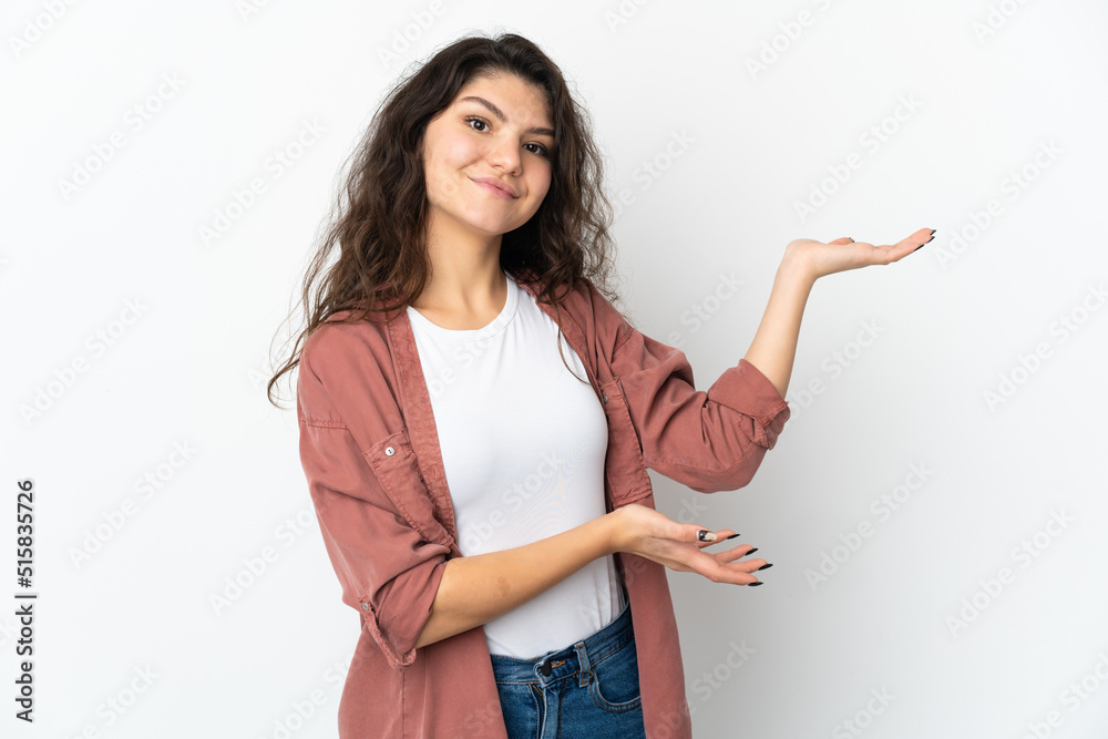 Teenager Russian girl isolated on white background extending hands to the side for inviting to come Teenager Russian girl isolated on white background extending hands to the side for inviting to come