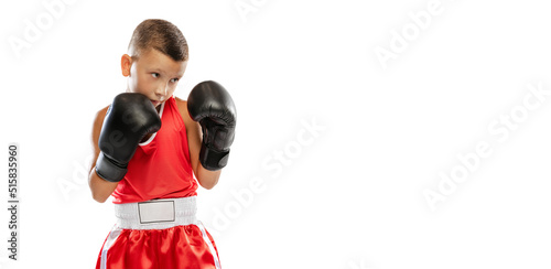 Portrait of active boy, beginner boxer in sports gloves and red uniform isolated on white background. Concept of sport, movement, studying, achievements, lifestyle. © master1305