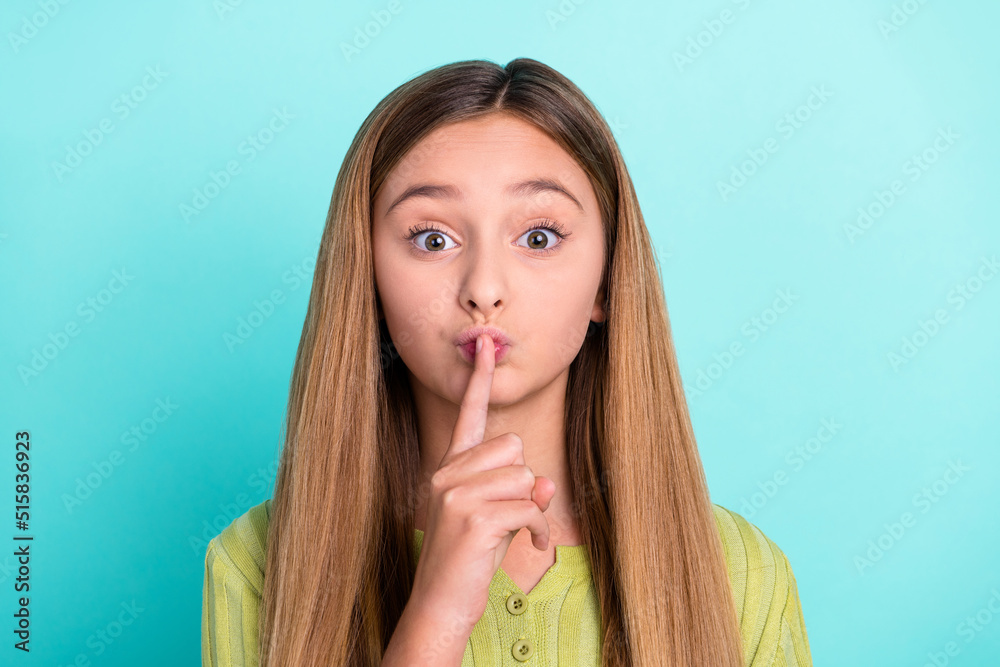 Naklejka premium Photo of little girl finger cover lips demonstrate shh gesture isolated on turquoise color background