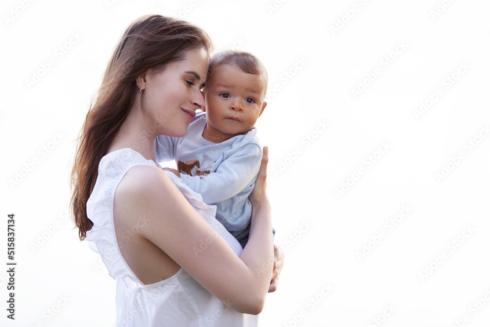 Mother hugs and holds child in her arms isolated on white background. Beautiful multiracial family Mother hugs and holds child in her arms isolated on white background. Beautiful multiracial family