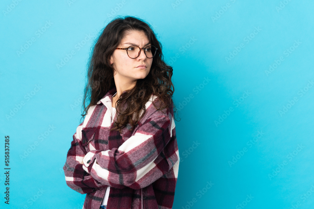 Teenager Russian girl isolated on blue background keeping the arms crossed Teenager Russian girl isolated on blue background keeping the arms crossed