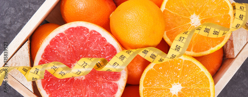 Fresh juicy fruits as source minerals or vitamins and tape measure. Dieting, slimming and healhy lifestyles photo