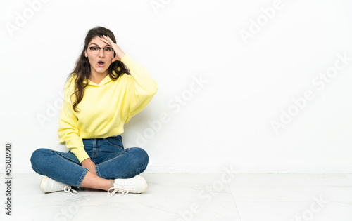 Teenager Russian girl sitting on the floor has realized something and intending the solution