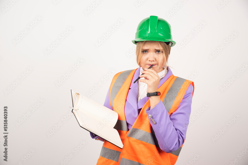 Young female builder in helmet with tablet on white background Young female builder in helmet with tablet on white background