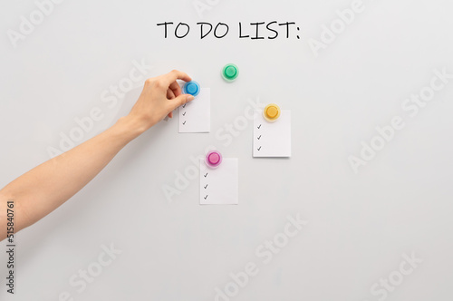 Image of white board and hand attaching pieces of paper to the magnetic board.