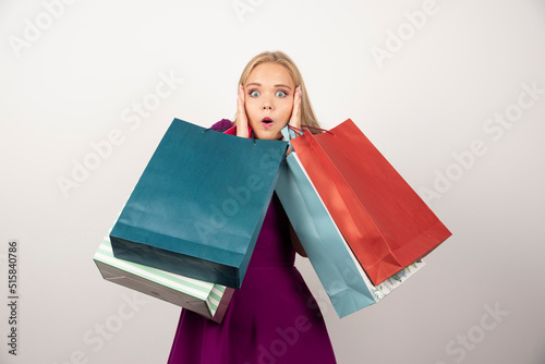 Surprised woman carrying shopping bags while covering her ears © azerbaijan-stockers