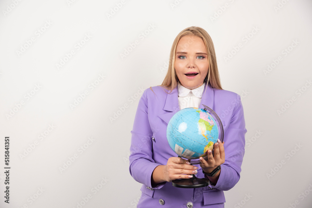 Female teacher holding globe with both hands Female teacher holding globe with both hands