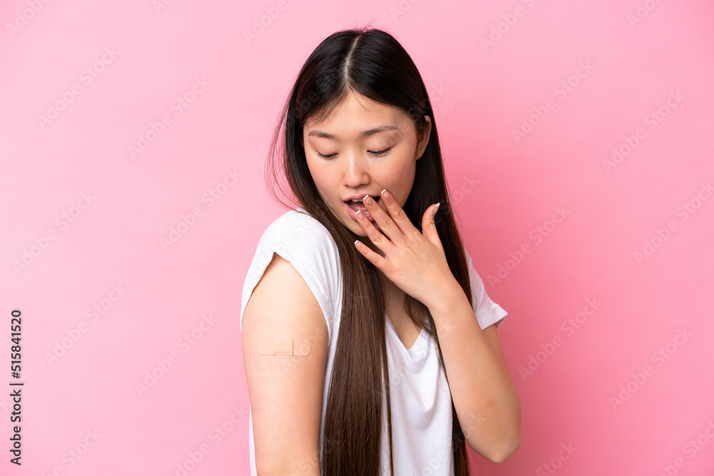 Young Chinese woman wearing a band aids isolated on pink background with surprise and shocked facial expression Young Chinese woman wearing a band aids isolated on pink background with surprise and shocked facial expression