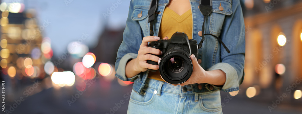 Professional photographer with modern camera and blurred view of beautiful city in evening. Banner design Professional photographer with modern camera and blurred view of beautiful city in evening. Banner design