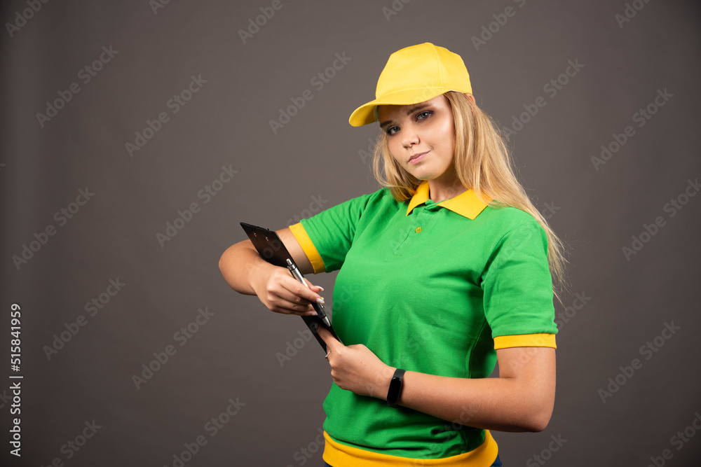 Young female courier with pencil and clipboard Young female courier with pencil and clipboard
