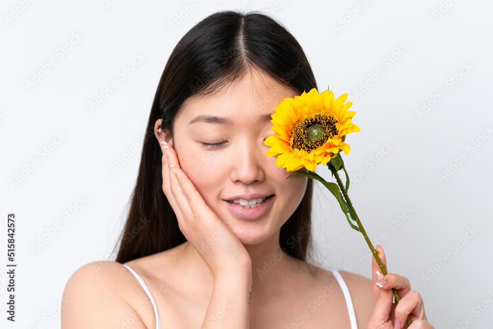 Young Chinese woman isolated on white background holding a sunflower while smiling. Close up portrait Young Chinese woman isolated on white background holding a sunflower while smiling. Close up portrait
