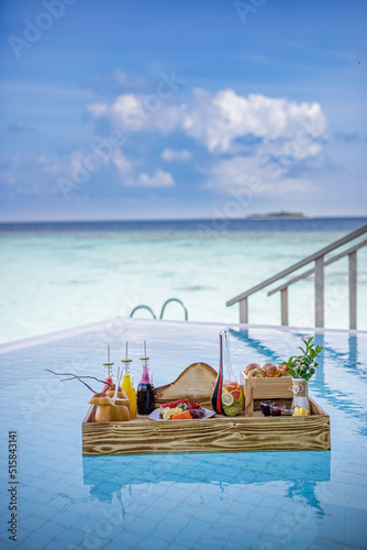 Breakfast in swimming pool, floating breakfast in luxurious tropical resort. Table relaxing on calm pool water, healthy breakfast and fruit plate by resort pool. Tropical couple beach luxury lifestyle © icemanphotos