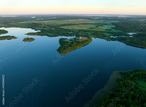 Lake in rural, aerial view. Freshwater Lakes. Abandoned Trinity Church in village of Belaya Tserkov. Lake Chereiskoye in Chereya village. Lighthouse on island. Panoramic landscape view of river.