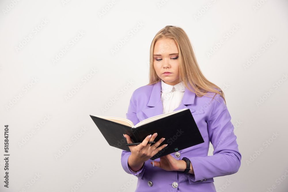 Portrait of young business woman standing and looking on clipboard Portrait of young business woman standing and looking on clipboard