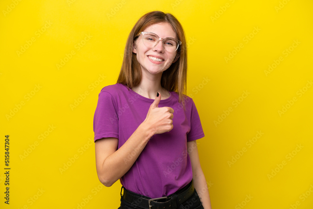 Young English woman isolated on yellow background giving a thumbs up gesture Young English woman isolated on yellow background giving a thumbs up gesture