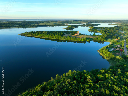 Lake in rural, aerial view. Freshwater Lakes. Abandoned Trinity Church in village of Belaya Tserkov. Lake Chereiskoye in Chereya village. Lighthouse on island. Panoramic landscape view of river.