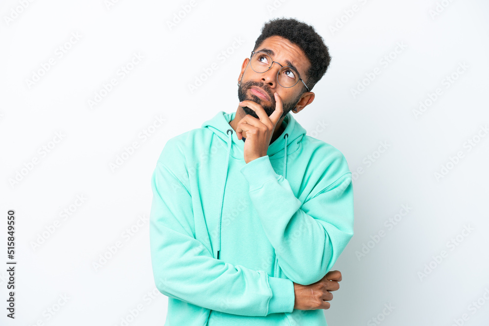 Young Brazilian man isolated on white background having doubts Young Brazilian man isolated on white background having doubts