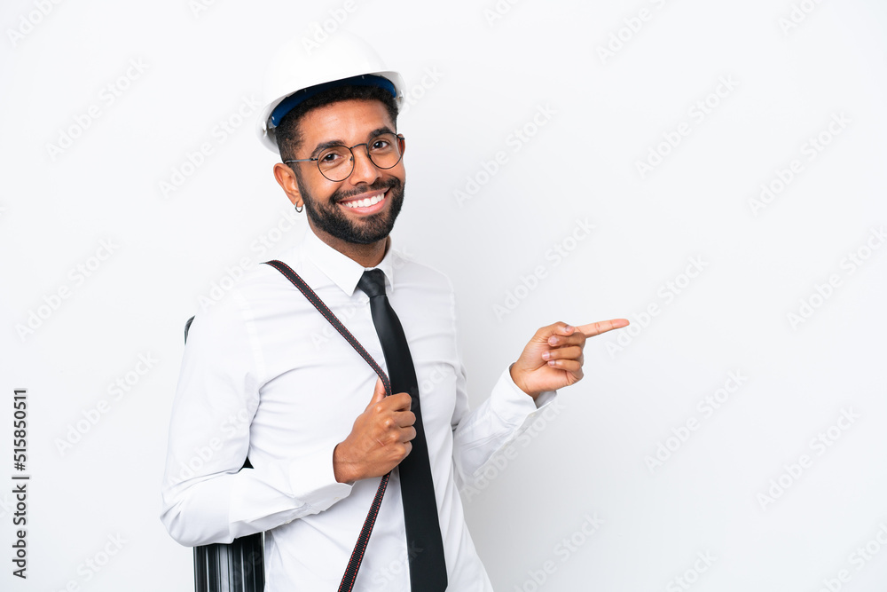 Young architect Brazilian man with helmet and holding blueprints isolated on white background pointing finger to the side Young architect Brazilian man with helmet and holding blueprints isolated on white background pointing finger to the side