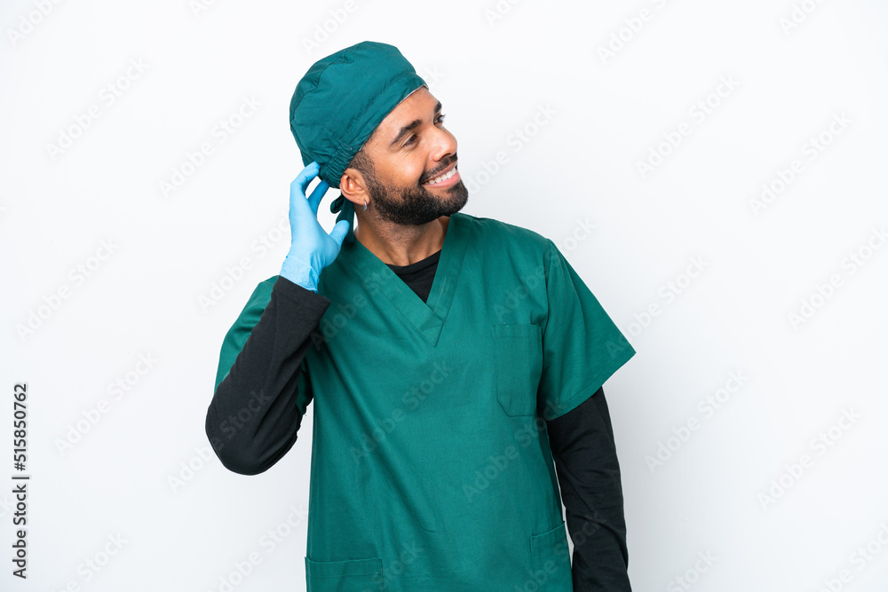 Surgeon Brazilian man in green uniform isolated on white background thinking an idea