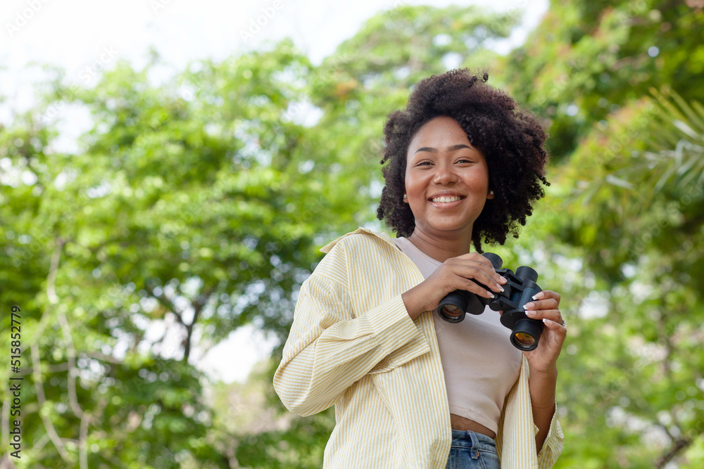 Close-up of attractive African American woman standing in nature. Happy young woman looking at the camera. Close-up of attractive African American woman standing in nature. Happy young woman looking at the camera.