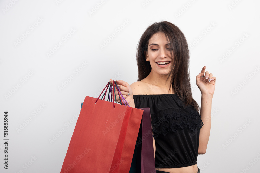 Female model posing with shopping bags on white background
