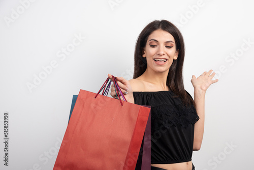 Female model holding shopping bags on white background