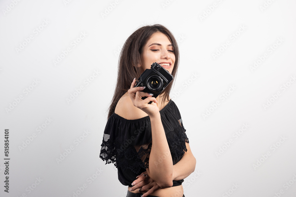 Pretty woman holding camera on white background Pretty woman holding camera on white background