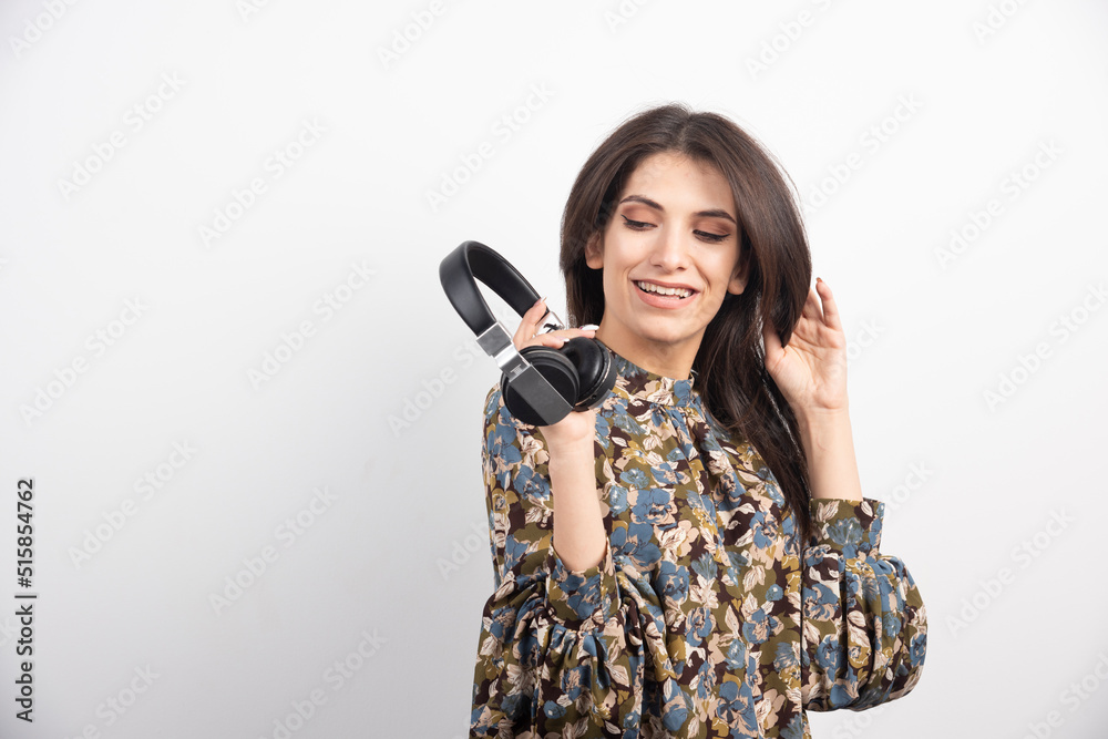 Young woman posing with headphones on white background Young woman posing with headphones on white background