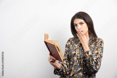 Brunette woman reading book on a white background