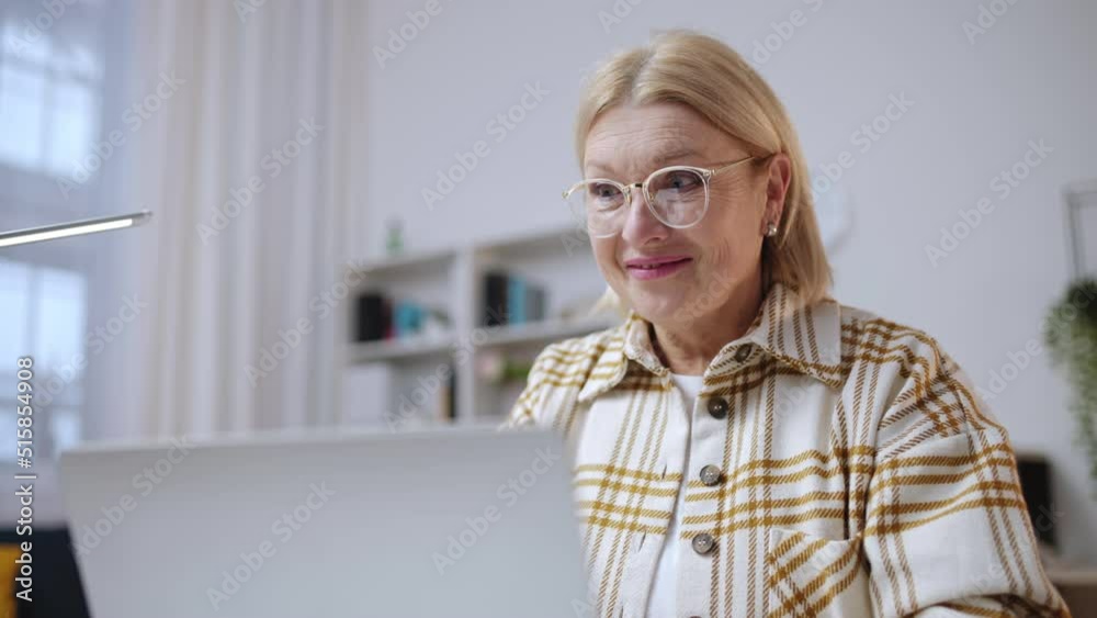 Mature woman receiving good news on laptop, getting project grant, amazement Mature woman receiving good news on laptop, getting project grant, amazement