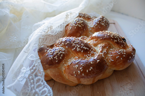 Two challah breads for Shabbat on wood cutting board