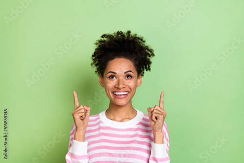 Photo of excited pretty lady dressed pink pullover pointing up empty space isolated green color background