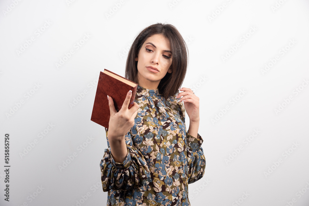 Pretty brunette woman looking at a book on a white background Pretty brunette woman looking at a book on a white background