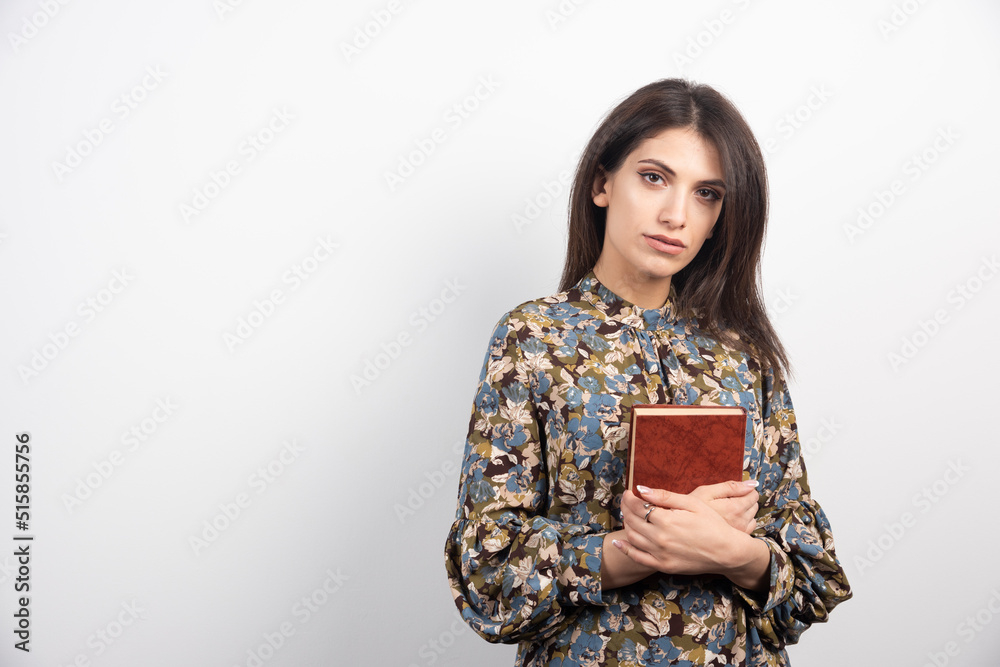 Pretty brunette woman holding a book on a white background Pretty brunette woman holding a book on a white background