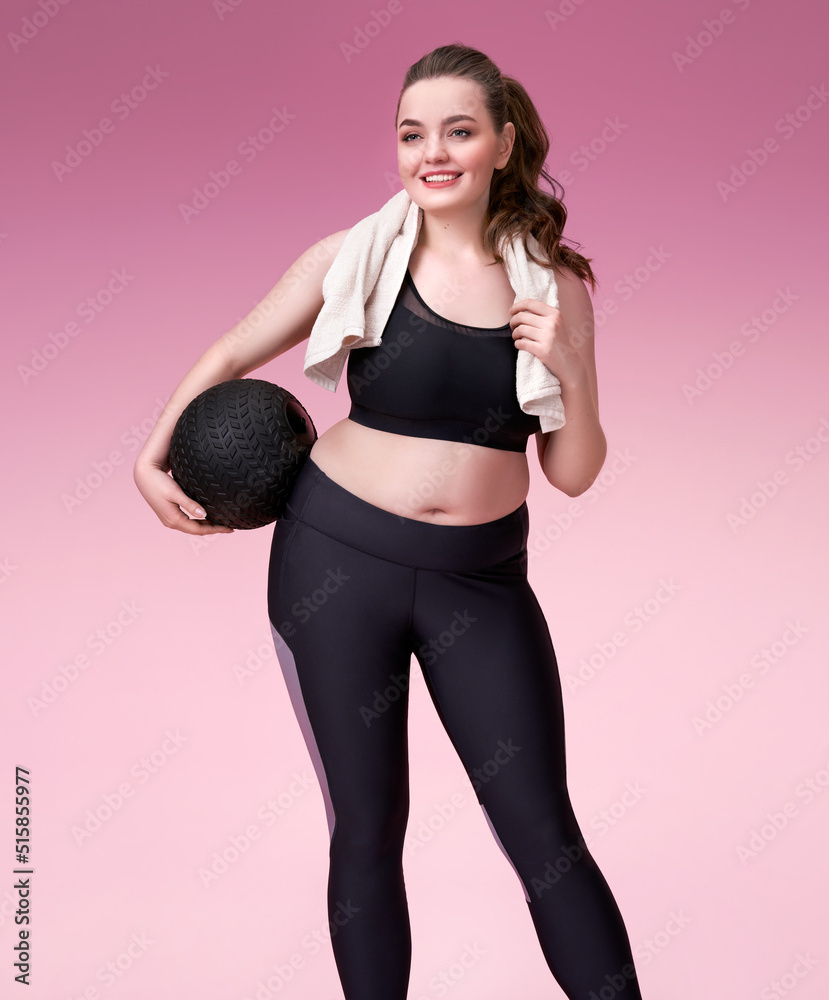 Sporty girl resting after training. Photo of pretty model with curvy figure in black sportswear on pink background. Sports motivation and healthy lifestyle Sporty girl resting after training. Photo of pretty model with curvy figure in black sportswear on pink background. Sports motivation and healthy lifestyle