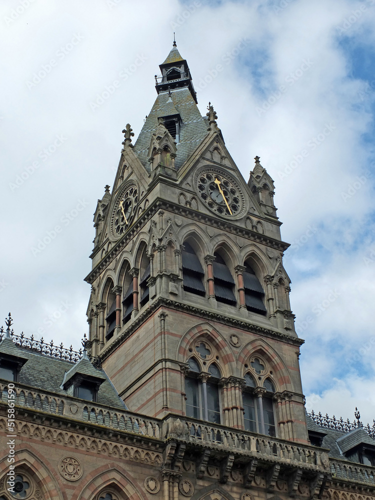close up of the clock tower of chester town hall against a blue cloudy sky
