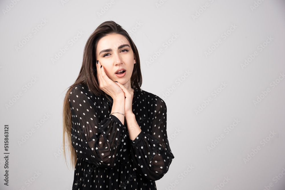 Portrait of tired yawning girl standing over a gray background Portrait of tired yawning girl standing over a gray background