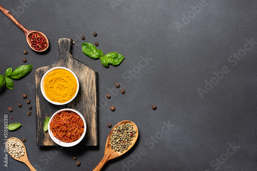 Assortment of aromatic herbs and spices on black rustic background with copy space for your design top view.