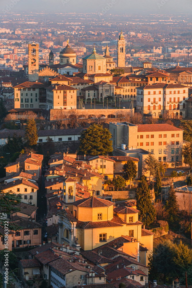 The city of Bergamo, its historic center and the hills, with the lights of the sunset, at the end of a winter day - February 2022.